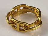 a gold ring with a chain on it on a white surface
