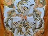 an orange and white scarf with a bird and flowers on it