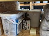 two buckets of paint sitting on a shelf in a garage
