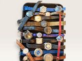 many watches stacked on top of each other in a case
