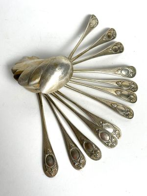a silver spoon and spoon rest on a white surface