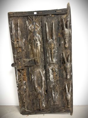 an old wooden door with carvings on it in a white room