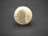 a white marble ball sitting on a black surface