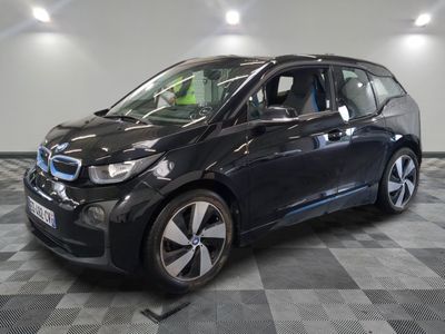 the bmw i3 is parked on a checkered floor in a garage