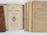 several old books sitting on top of each other on top of a table
