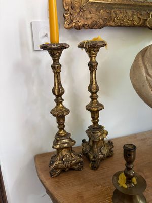 three candles that are sitting on a table next to a mirror