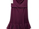 une robe violette suspendue à un cintre sur un mur blanc