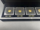 three gold coins are in a black box on a table