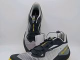 une paire de chaussures de course noires et jaunes sur fond blanc
