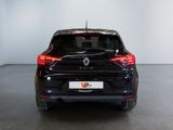 the rear end of a black car in a room with a white wall