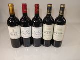 six bottles of red wine are lined up on a counter
