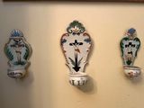 trois vases décoratifs accrochés au mur les uns à côté des autres