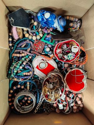 une boîte en carton remplie de bijoux variés et d'autres objets