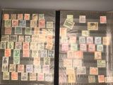 an open book with stamps on it sitting on top of a table