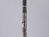 a close up of a silver and black clarinet on a clear surface