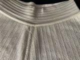 the bottom of a white dress with pleas on it