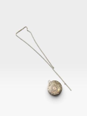 un collier en argent et en or avec une pièce suspendue à une chaîne