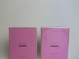 a pair of pink perfume bottles sitting on top of a white table