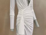 the mannequin is wearing a white dress with long sleeves