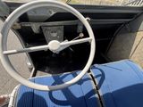 une valise bleue posée sur le plancher d'une voiture