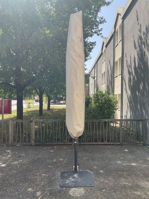 un grand parapluie fixé à un mât devant un immeuble