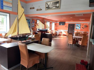 a sailboat in the middle of a room with tables and chairs