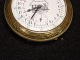 a gold pocket watch sitting on a black surface