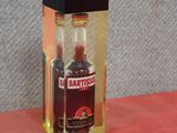 a small bottle of liquor sitting on a red surface