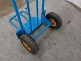a blue hand truck with a blue handle on the sidewalk
