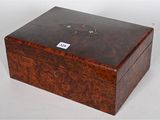 an old wooden box with a tag on it sitting on a white surface