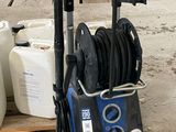 un nettoyeur haute pression bleu posé sur un plancher en bois