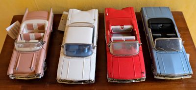 quatre petites voitures alignées sur une table