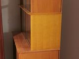 a tall wooden cabinet in the corner of a room
