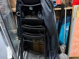 a black chair sitting next to a black chair in a garage