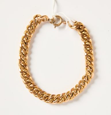 gros plan d'un bracelet en chaîne en or sur fond blanc