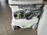 a vacuum that is sitting on the floor next to a refrigerator