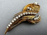 a close up of a gold brooch with diamonds on it