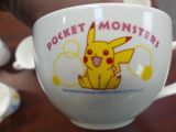 a person holding a cup that has a pikachu on it