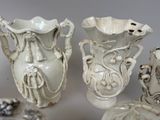 four white vases sitting next to each other on a table