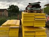 plusieurs piles de bois jaune empilées les unes sur les autres devant un camion