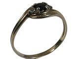 un gros plan d'une bague sertie d'un diamant noir sur fond blanc