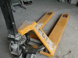 a fork lifter sitting on the ground in a garage