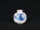 un petit vase blanc orné d'un poisson bleu