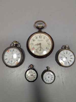 cinq types différents de montres de poche exposées au mur