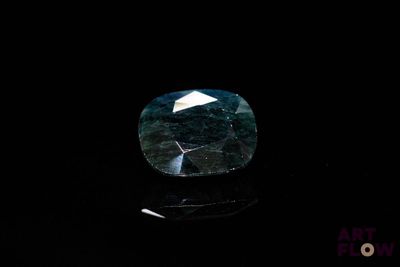 a close up of a blue diamond on a black surface