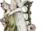 a statue of a woman holding a bird in a vase