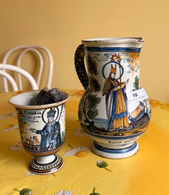 un pichet et une tasse posés sur une table recouverte d'une nappe jaune