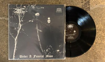 a black vinyl album with a picture of a man standing in front of a tree