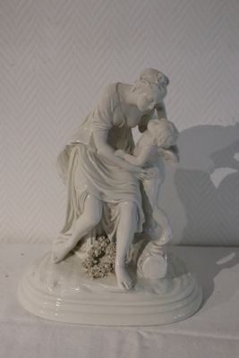 a statue of a woman and a child sitting on a table