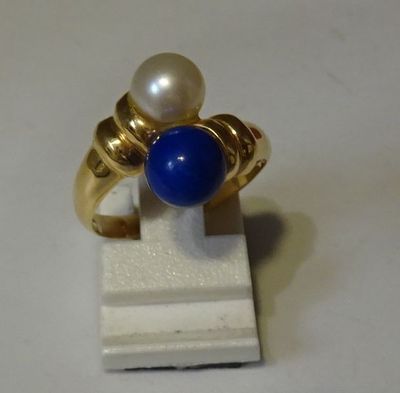 une bague ornée d'une perle et d'une pierre bleue